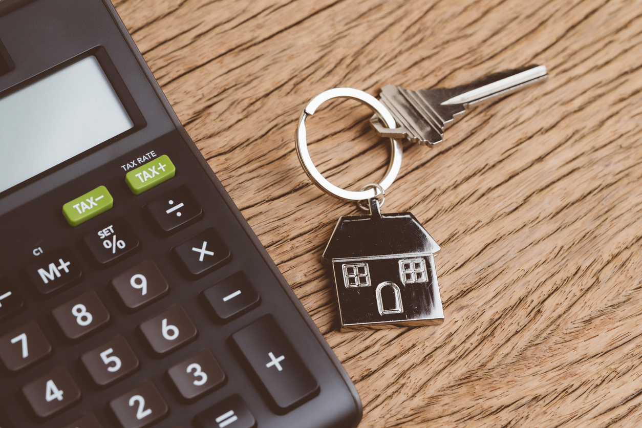 Calculator on a table with a set of keys with a house on the keychain
